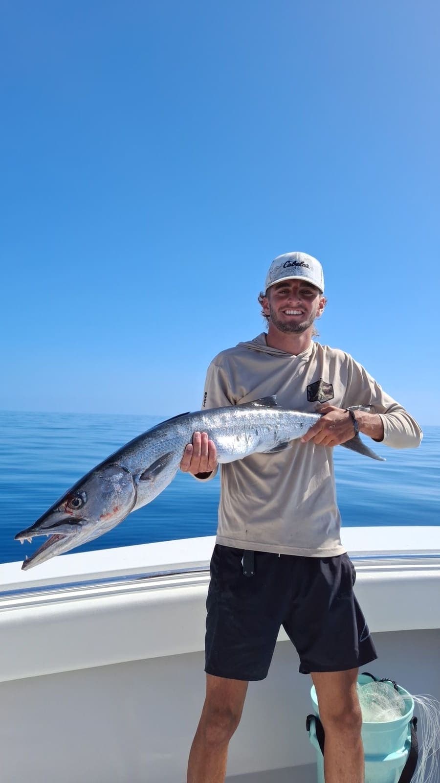 Captain Marcus Terrero holding a big barracuda on a blue-water day offshore