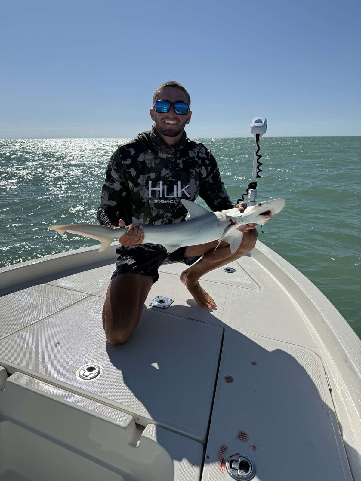 Guest kneeling with a blacktip shark caught on the flats
