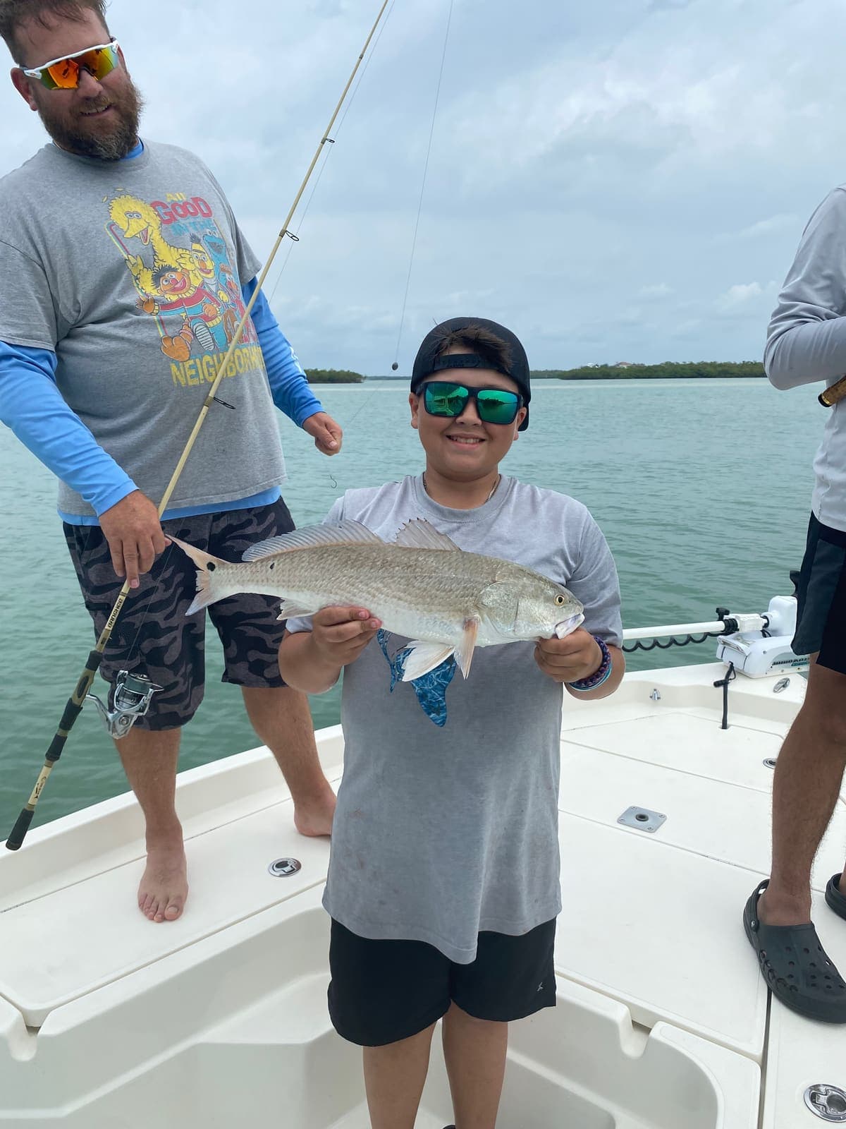 Young angler proudly holding a redfish on a family trip
